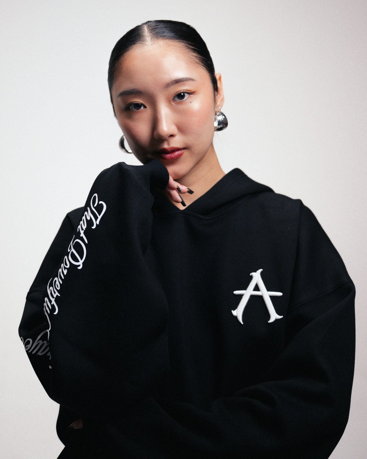 The A-Hoodie in black with script down the sleeve